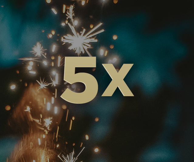 5X in the middle of blurry sparklers in the dark background 