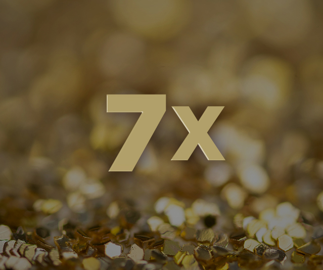 '7X' in the middle with an image of partially blurred gold sequins in the background